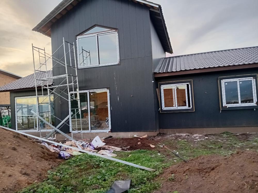 Vivienda con revestimiento oscuro y teja metálica