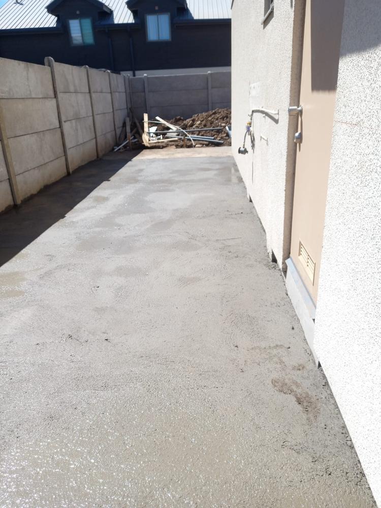 Radier de hormigón junto a muro de vivienda