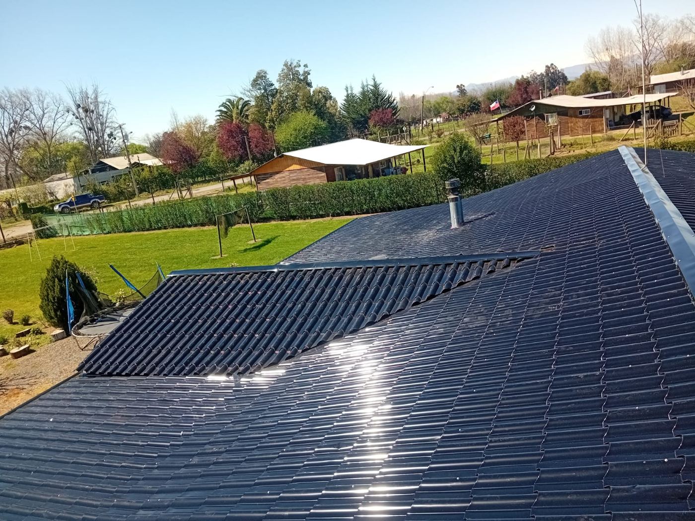 Techumbre con teja metálica negra recién instalada en una casa de campo