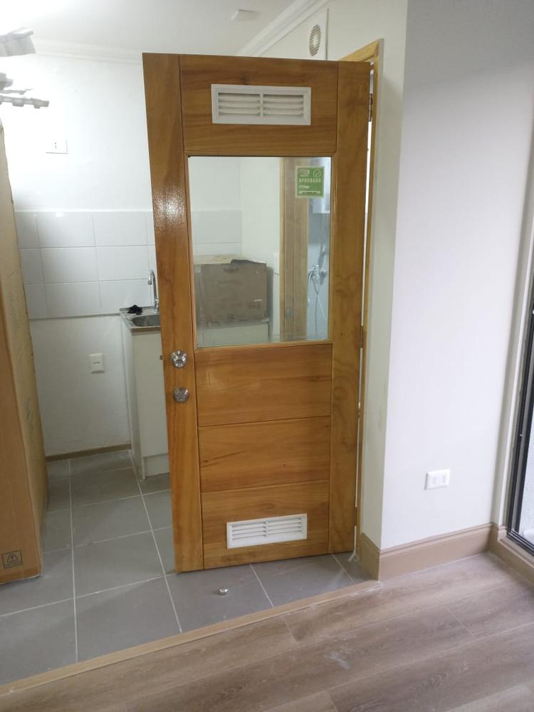 Puerta de madera con vidrio y rejillas de ventilación